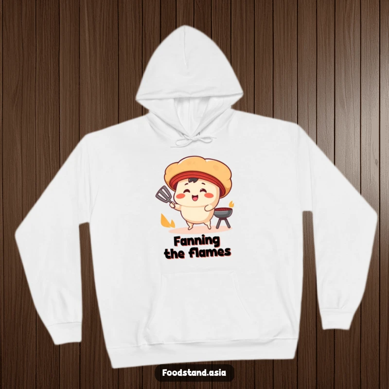 Funny Hoodie: A smiling bao bun character with tiny legs fans a cooking grill, offering humorous warmth and culinary vibes.